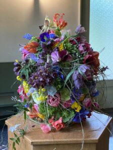 Urne ist mit bunten Blüten total beklebt