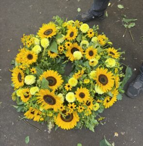 Rundgesteckter Trauerkranz aus verschiedenen Sonnenblumen