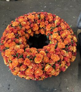 Rundgesteckter Trauerkranz aus orange Rosen eng gesteckt