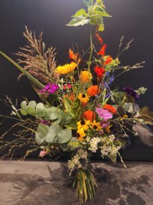 Üppiger, wild gebundener Blumenstrauß mit Dahlien, Kosmeen, Scabiosen und bunten Sommerblumen