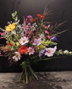 Bunter, locker gebundener Blumenstrauß mit Kosmeen, Rosen, Beeren und saisonalen Blüten