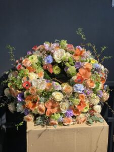 Rundgesteckter Trauerkranz aus verschiedenen bunten Blumen der Saison