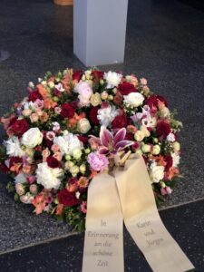 Rundgesteckter Trauerkranz aus verschiedenen bunten Blumen der Saison