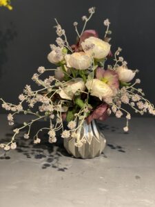 natürlich gebundener Blumenstrauß in leuchtenden , creme Tönen mit Ranunkeln , ergänzt durch filigrane Gräser und frisches Grün.