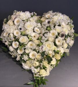 verschiedene weiße Blumen in Herzform gesteckt