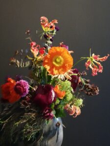 Wilder, natürlich gebundener Blumenstrauß im Frühjahr mit vielfältigen Blumen, ergänzt durch filigrane Gräser und frisches Grün.