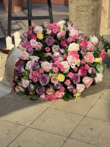 Rundgesteckter Trauerkranz aus verschiedenen bunten Blumen der Saison