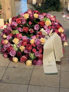 Rundgesteckter Trauerkranz aus verschiedenen bunten Blumen der Saison