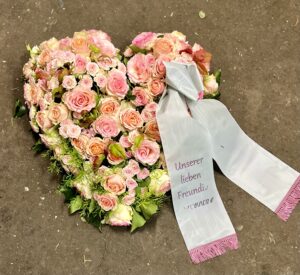Herz aus rosa Rosen mit Trauerschleife