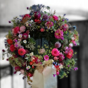 Rundgesteckter Trauerkranz aus verschiedenen bunten Blumen der Saison