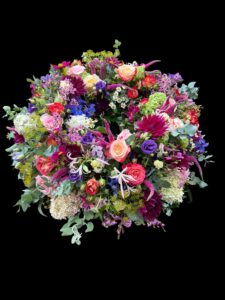 Rundgesteckter Trauerkranz aus verschiedenen bunten Blumen der Saison