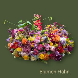 Rundgesteckter Trauerkranz aus verschiedenen bunten Blumen der Saison