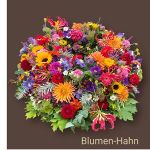 Rundgesteckter Trauerkranz aus verschiedenen bunten Blumen der Saison