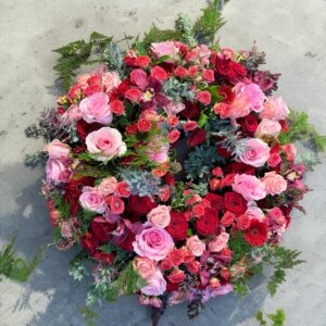 Rundgesteckter Trauerkranz aus verschiedenen bunten Blumen der Saison