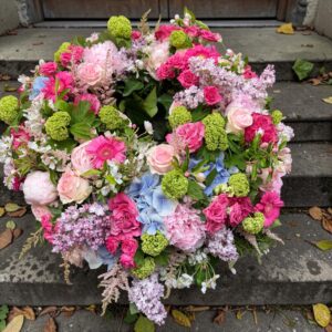 Rundgesteckter Trauerkranz aus verschiedenen bunten Blumen der Saison