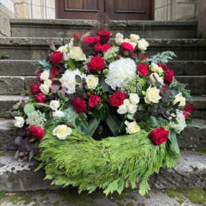 dekorativer Trauerkranz aus weißen und roten Blumen