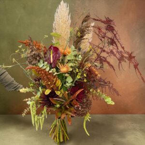 Wilder, natürlich gebundener Blumenstrauß in herbstllichen Farben Wiesenblumen, ergänzt durch filigrane Gräser und Laub